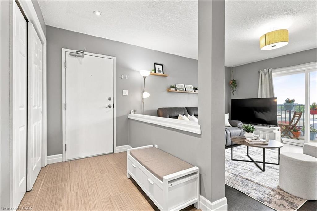 Entryway with wood-finish tile flooring, a white paneled closet, and a white entry door
