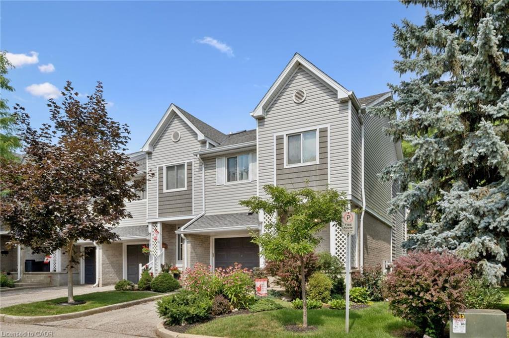 Townhome exterior featuring horizontal siding, gabled rooflines, and an attached garage