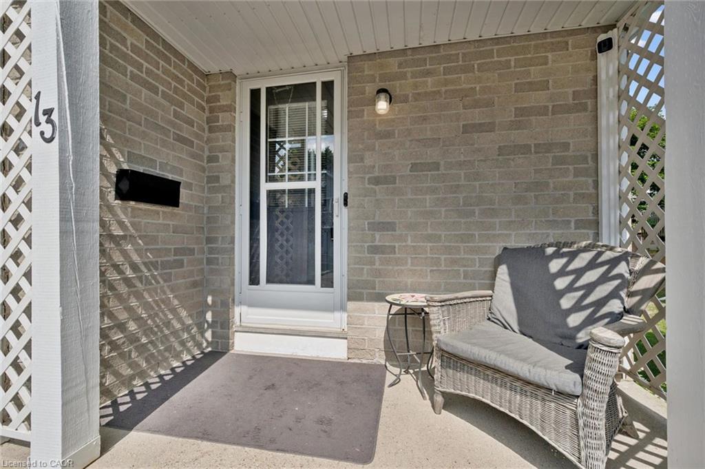 Brick exterior with a covered porch, featuring a white lattice accent and an exterior wall sconce