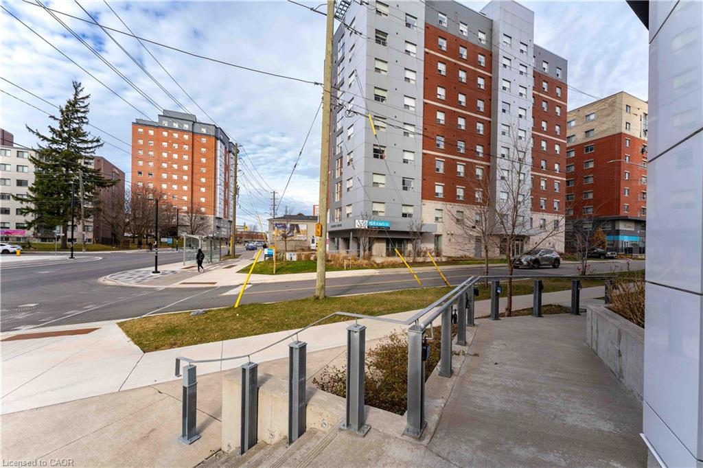 Modern building exterior featuring a concrete walkway, metal railings, and a landscaped perimeter