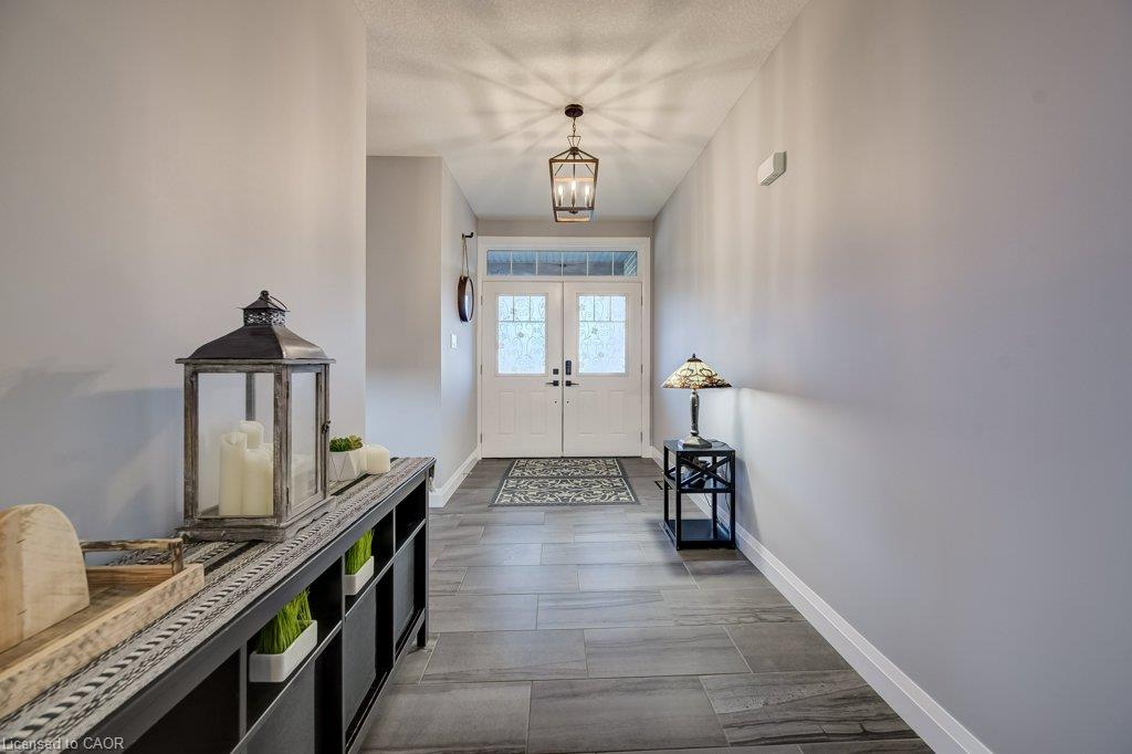 Entryway featuring tile flooring, white double doors with decorative glass inserts, impressive entrance to the house and the Living room.