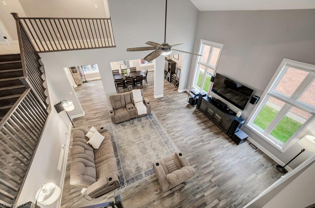 Two-story great room features a contemporary ceiling fan, and multiple windows