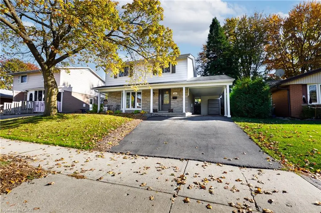 Split-level exterior featuring horizontal siding, stone veneer facade, covered front porch, and attached carport