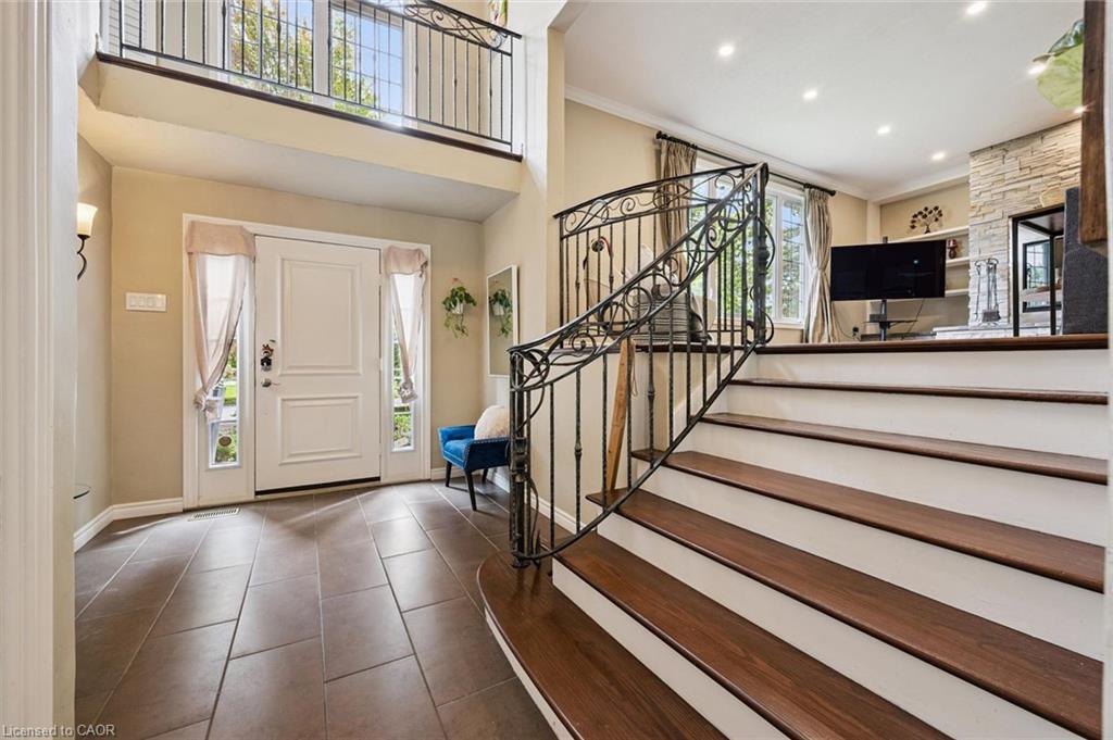 Two-story entryway featuring a decorative wrought iron staircase and a second-level balcony