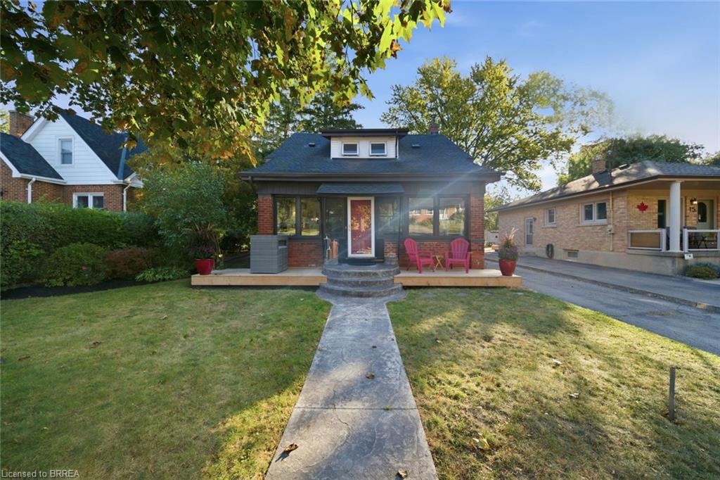 Brick facade residence with a dormer window, covered porch, and front deck