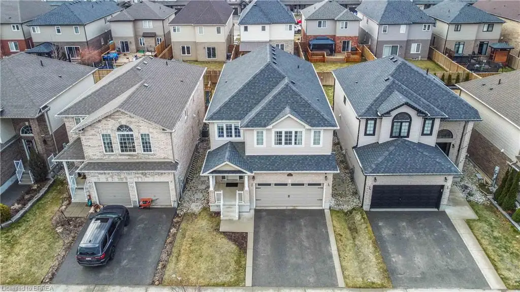 Two-story residence featuring a brick facade, asphalt shingle roofing, an attached double-car garage, a concrete driveway, and a front-facing gable roofline