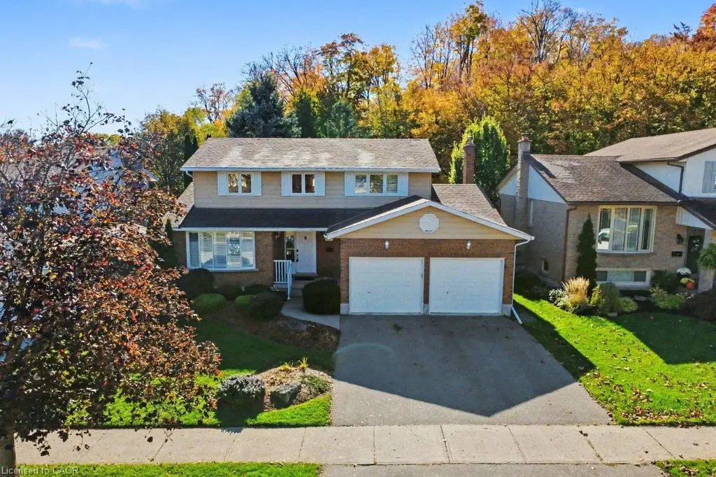 Two-story residence featuring a brick and horizontal siding exterior, attached two-car garage, asphalt shingle roof, and a paved driveway