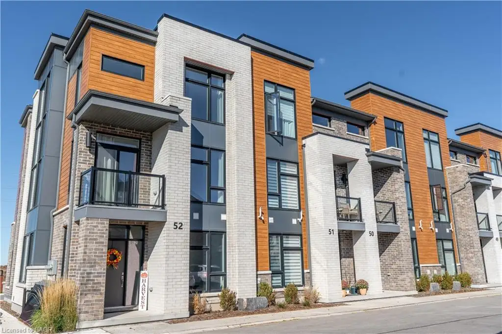 Modern multi-story exterior featuring light brick masonry, wood-finish paneling, dark-framed oversized windows, and integrated balconies with glass railings