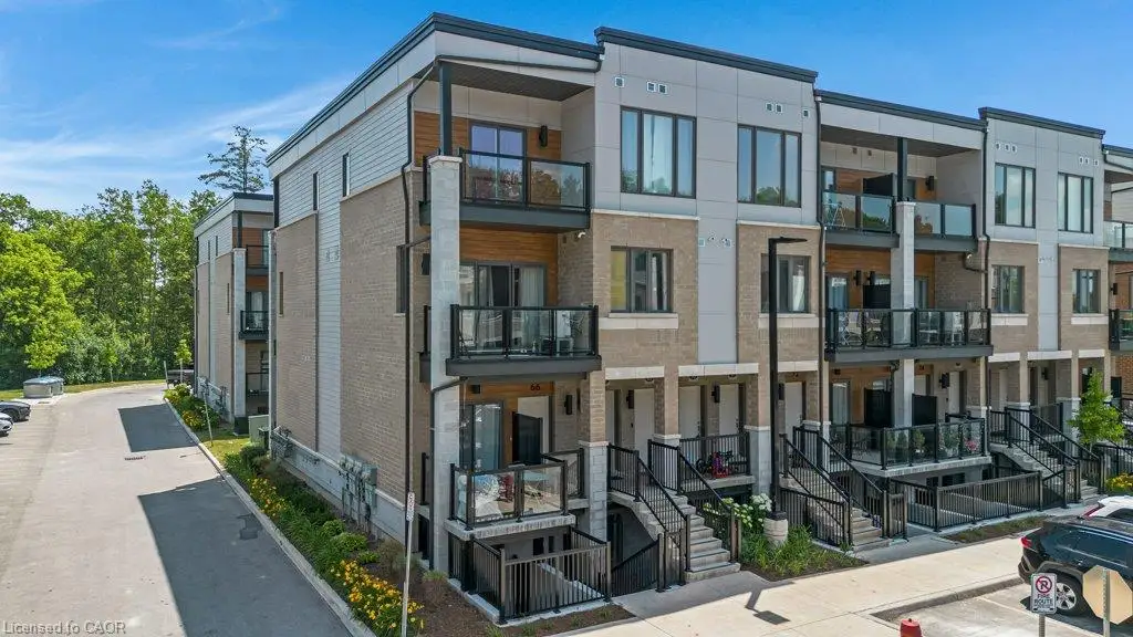 Modern townhouse featuring light brick and grey siding, glass-paneled balconies, and dark-framed windows