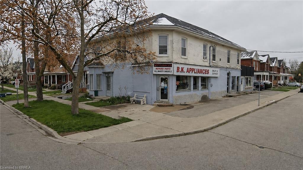 Corner property featuring a mixed-use commercial and residential building with a brick facade