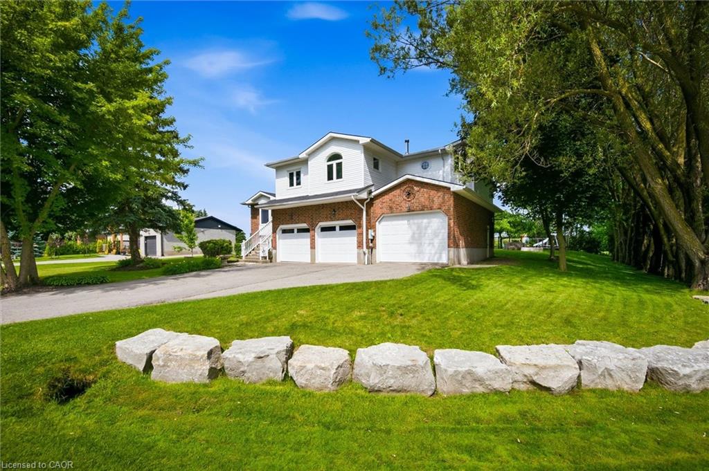 Brick and white siding two-story residence featuring a two-car garage with white garage doors