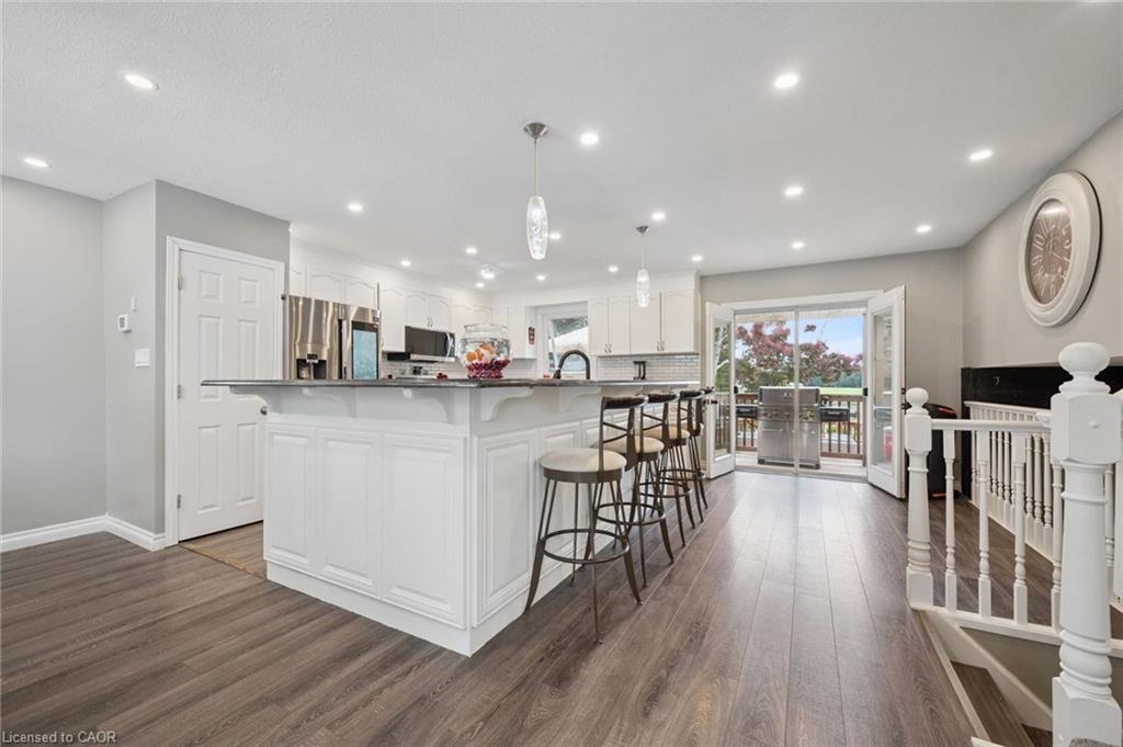 Spacious kitchen featuring white cabinetry, stainless steel appliances, a center island with seating, and recessed lighting