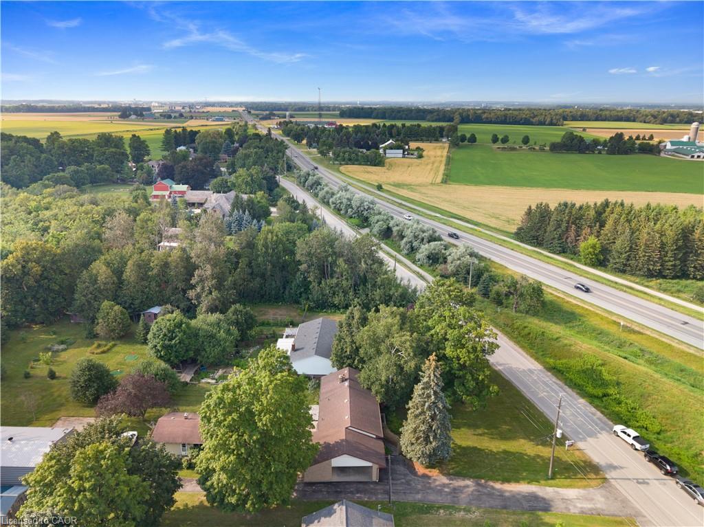 Expansive property featuring a brown shingle roofline, broad green lawn, and mature trees