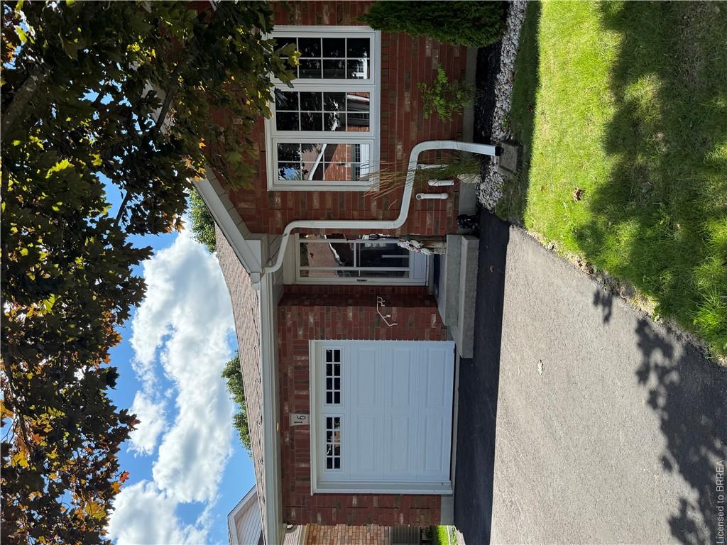 Brick exterior with white garage door and multi-pane windows
