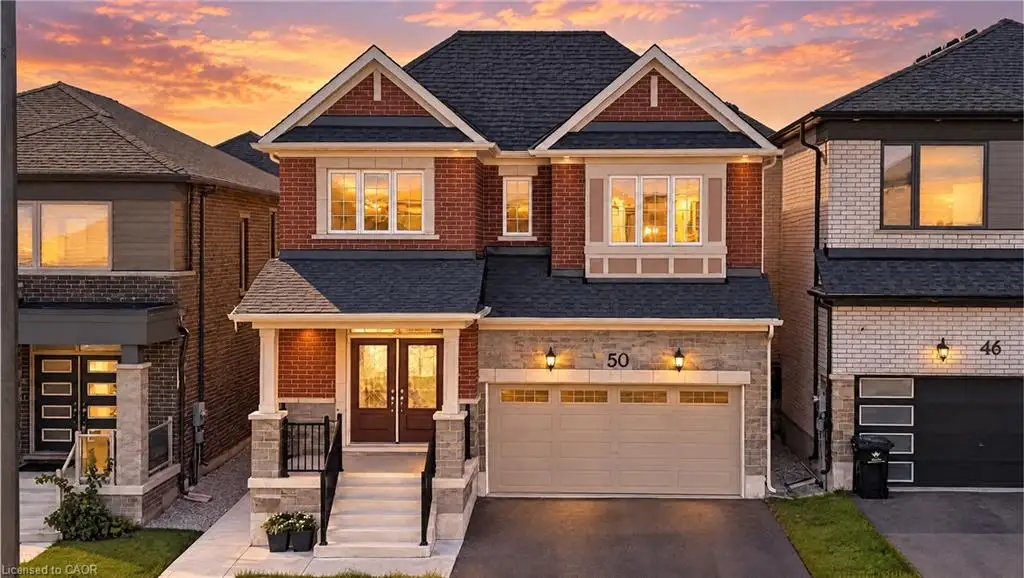 Two-story exterior featuring a brick and stone facade, double-door entrance with a covered porch, and an attached two-car garage