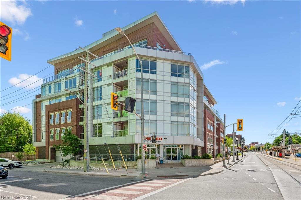 Modern mixed-use building featuring extensive glazing, multiple balconies, and a distinctive sloped roofline