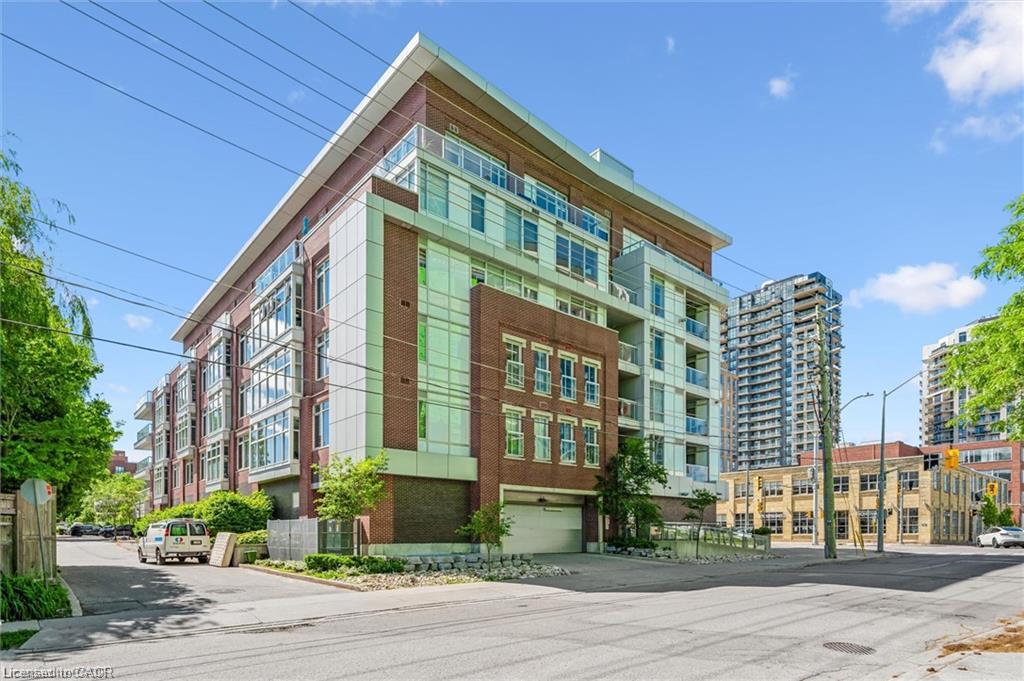 Contemporary building facade featuring brick and paneling accents, multiple private balconies, extensive window systems, and an integrated garage