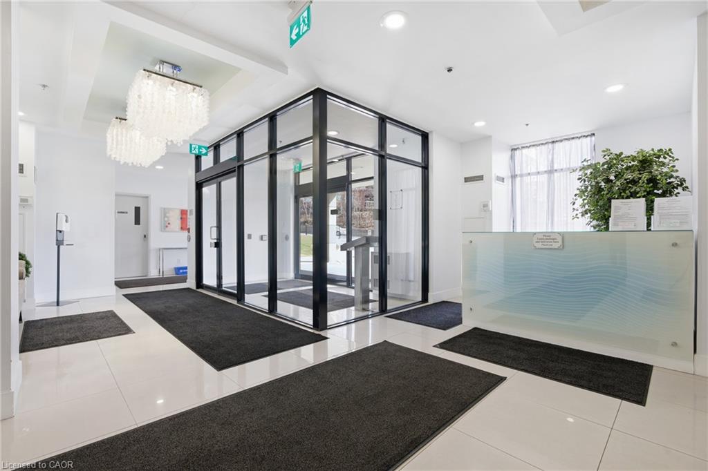 Lobby entrance featuring glass doors, white tile flooring, and a reception desk