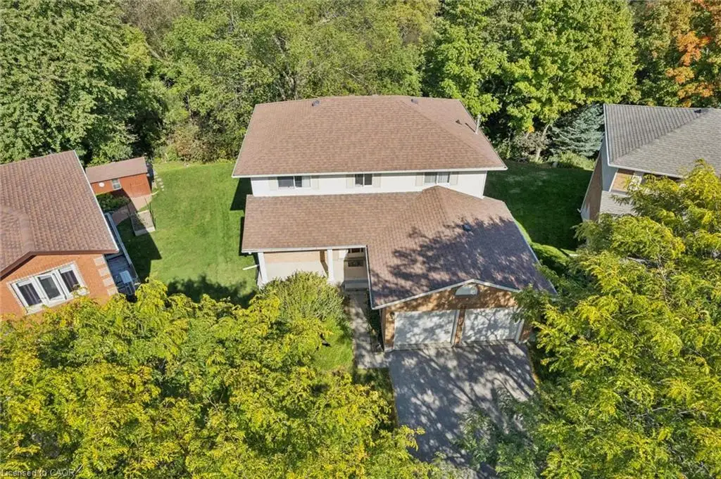 Two-story residential structure with a brown shingle roof, attached two-car garage, and a paved driveway