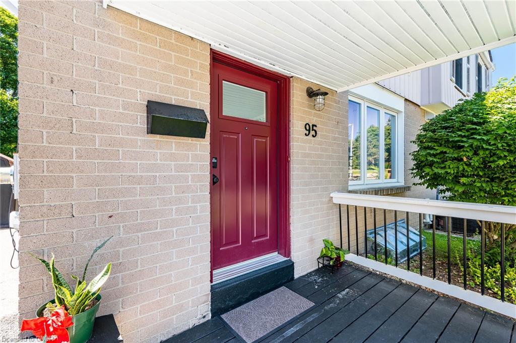 Welcoming front entry featuring a striking burgundy six-panel door with sidelights, positioned on a composite deck with black base trim