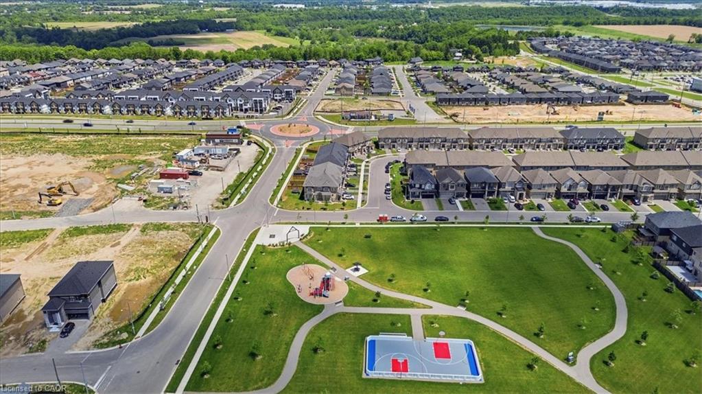 Expansive green space featuring recreational amenities including a basketball court and playground structures