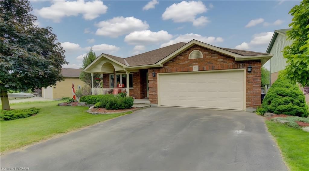 Brick exterior featuring an attached two-car garage with a light-toned door