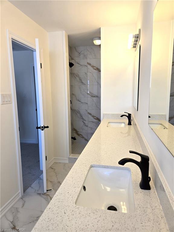 Dual undermount sinks with matte black fixtures set into a speckled white countertop