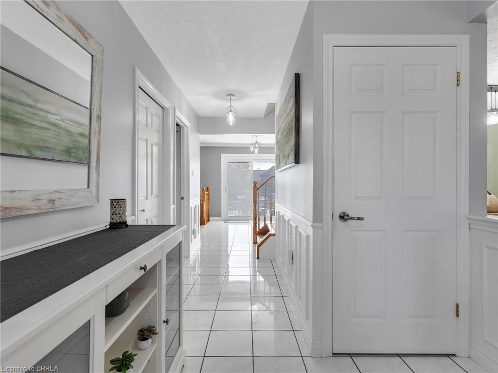 Tiled flooring, white wainscoting, white doors, and a built-in console cabinet