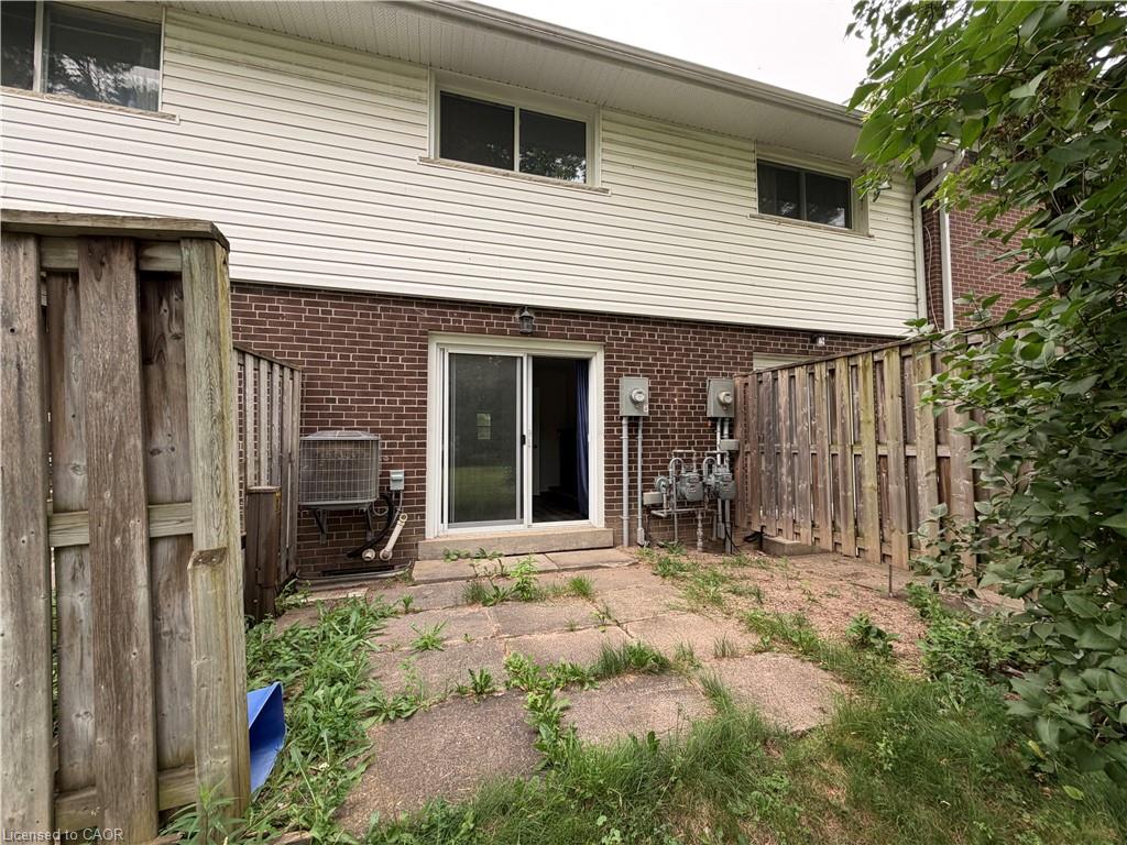 Rear exterior featuring a brick and vinyl siding