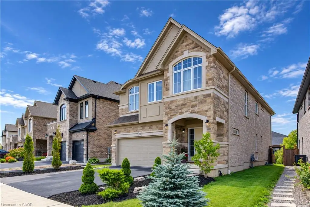 Stone and brick facade featuring an arched entryway, gabled roofline, multi-pane windows, and an integrated two-car garage