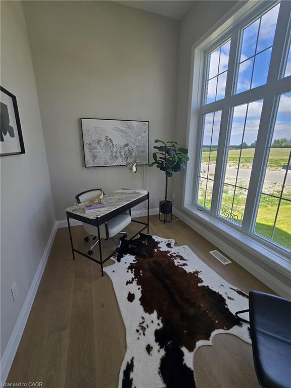 Bright interior space featuring light wood-finish flooring, tall ceilings, and a large multi-pane window