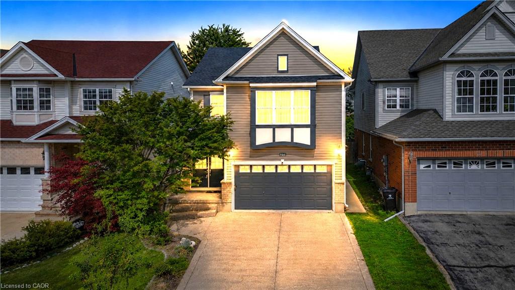 Split-level facade featuring an attached garage, bay window, and a concrete driveway