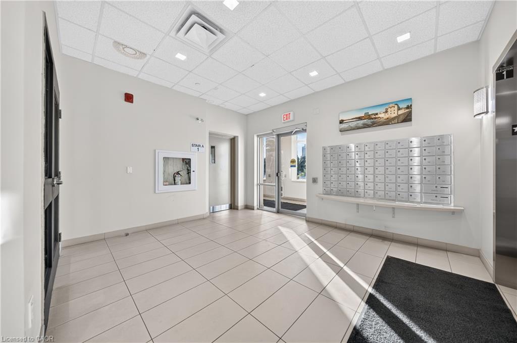 Building entryway featuring light-toned tile flooring, recessed ceiling lighting, and a wall of individual mailboxes