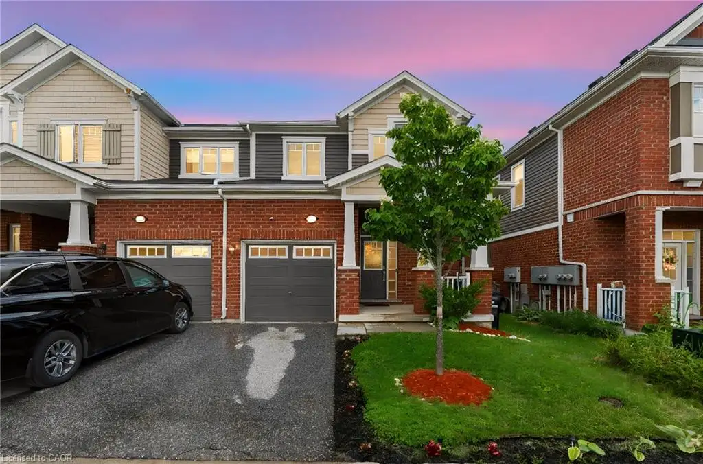 Brick and siding exterior with multiple gables, two single-car garages, a paved driveway, and a landscaped front yard