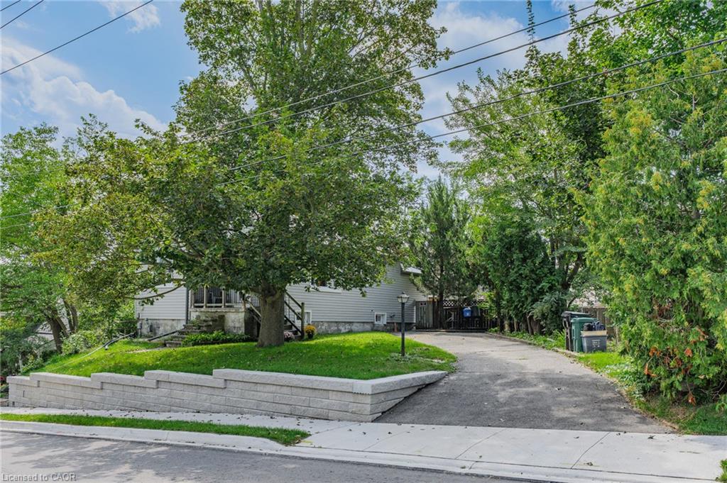 Paved driveway leading to the residence, complemented by mature trees and a manicured lawn