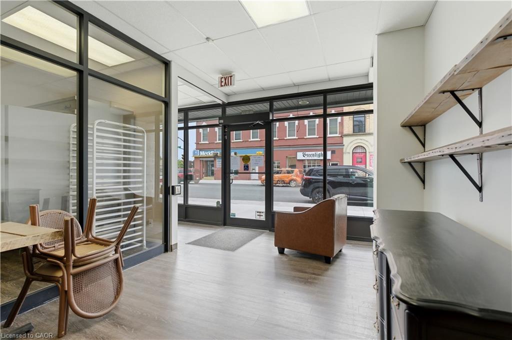 Interior retail space featuring front-facing glass storefront, wood-finish flooring, and recessed lighting