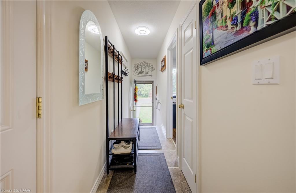 Hallway with tiled flooring, white walls, and recessed lighting