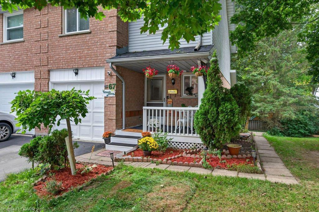 Brick facade with light-toned siding, covered front porch with white railings, stepped entry, and a paved walkway