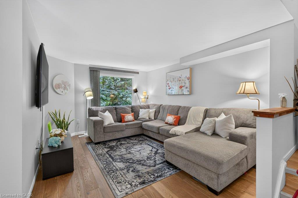 Hardwood-finish flooring, recessed lighting, and a large window with vertical blinds
