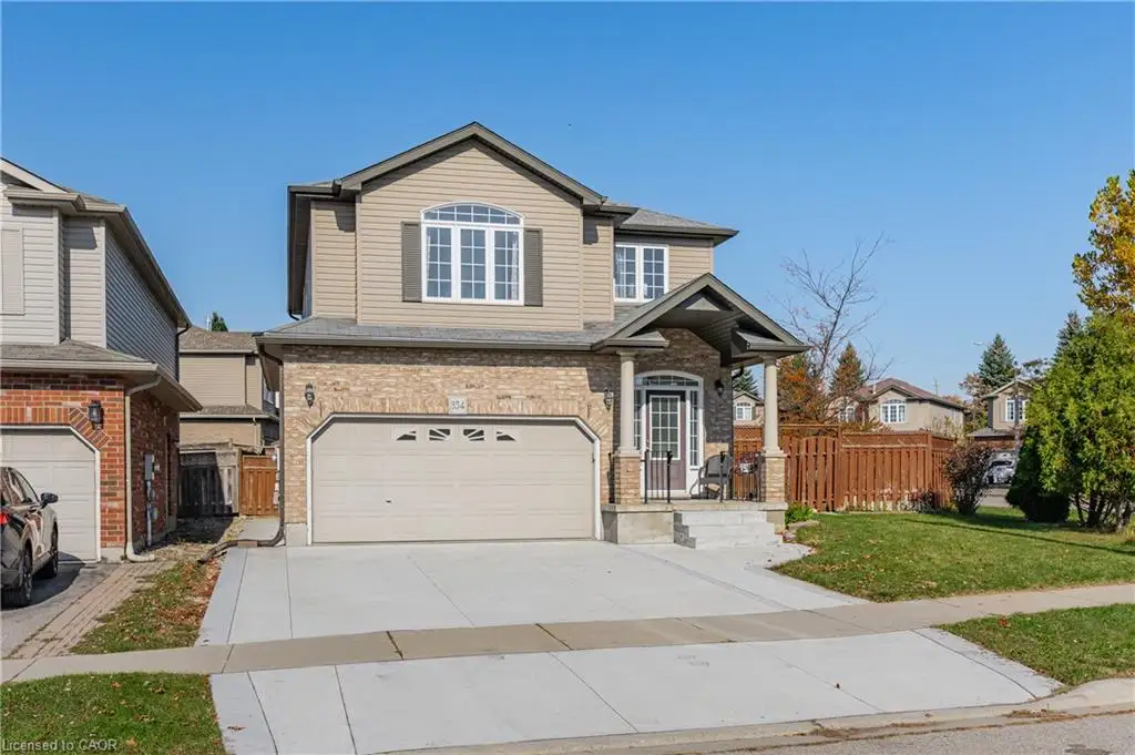 Two-story residence featuring a brick and horizontal siding exterior, arched window detailing, covered front entryway with decorative pillars, concrete driveway, and attached two-car garage