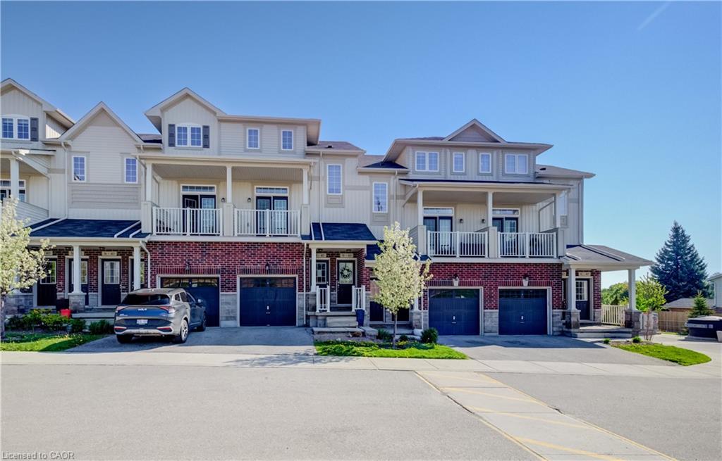 Townhome exteriors featuring brick and siding finishes, individual garages, and covered front porches