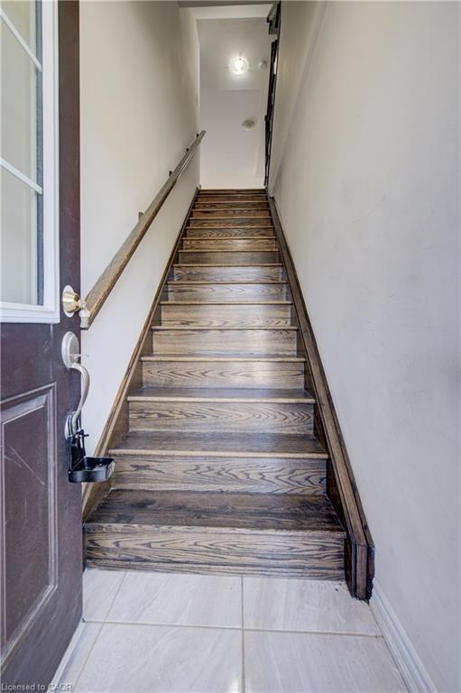 Wood-finish staircase with a coordinating handrail and light-colored wall paint