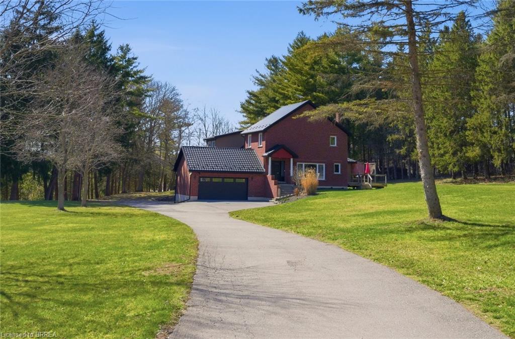 View of front of house with a front lawn, an attached garage, and driveway