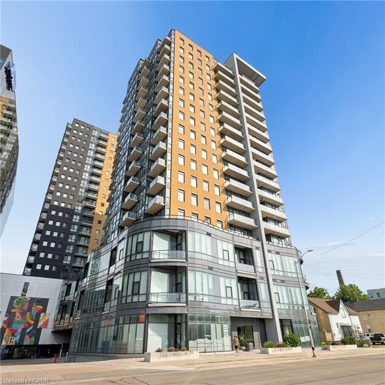 Modern high-rise building featuring a glass and panel facade, multiple private balconies, and ground-floor retail spaces