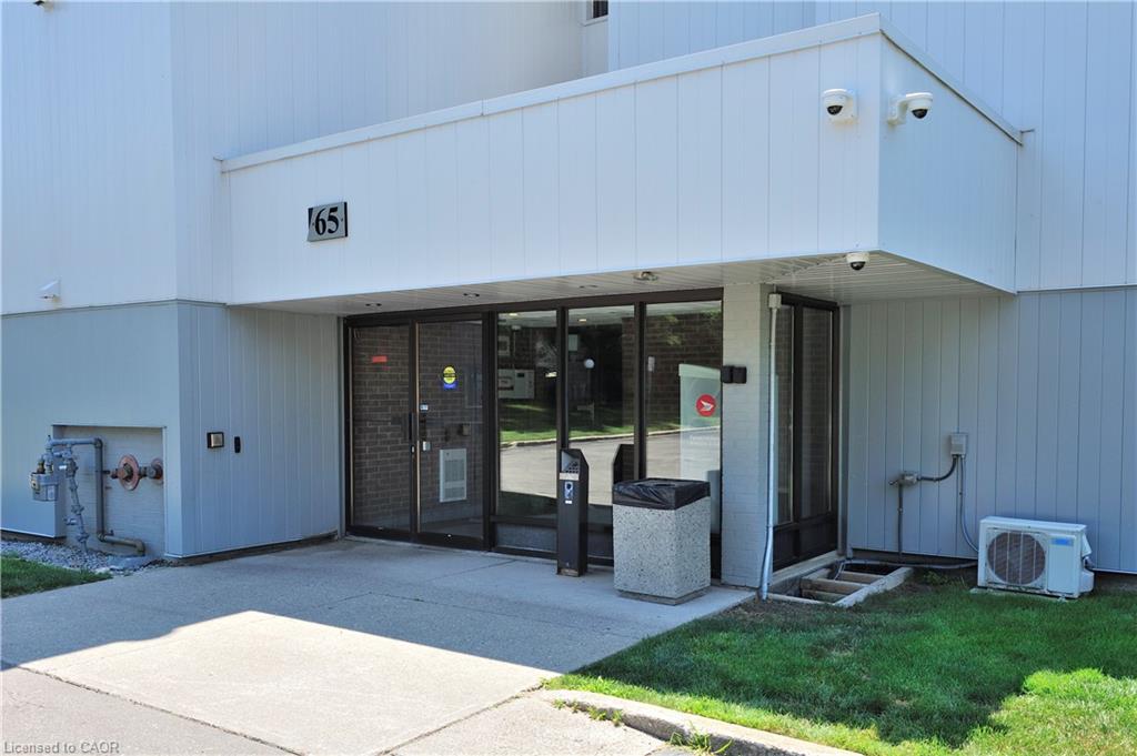 Building entrance featuring glass double doors, an overhead canopy, and a concrete approach