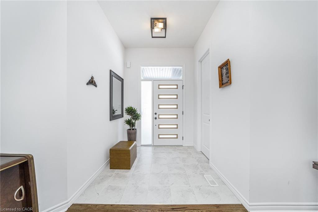 Entryway featuring a modern door with rectangular glass inserts, a transom window, tile flooring, and a contemporary ceiling light fixture