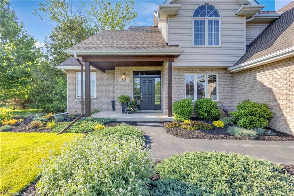 Brick and siding exterior featuring a covered entryway with decorative columns