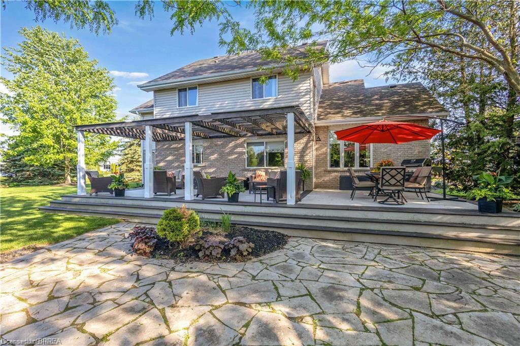 Multi-level rear deck with a pergola-covered section and an expansive flagstone patio