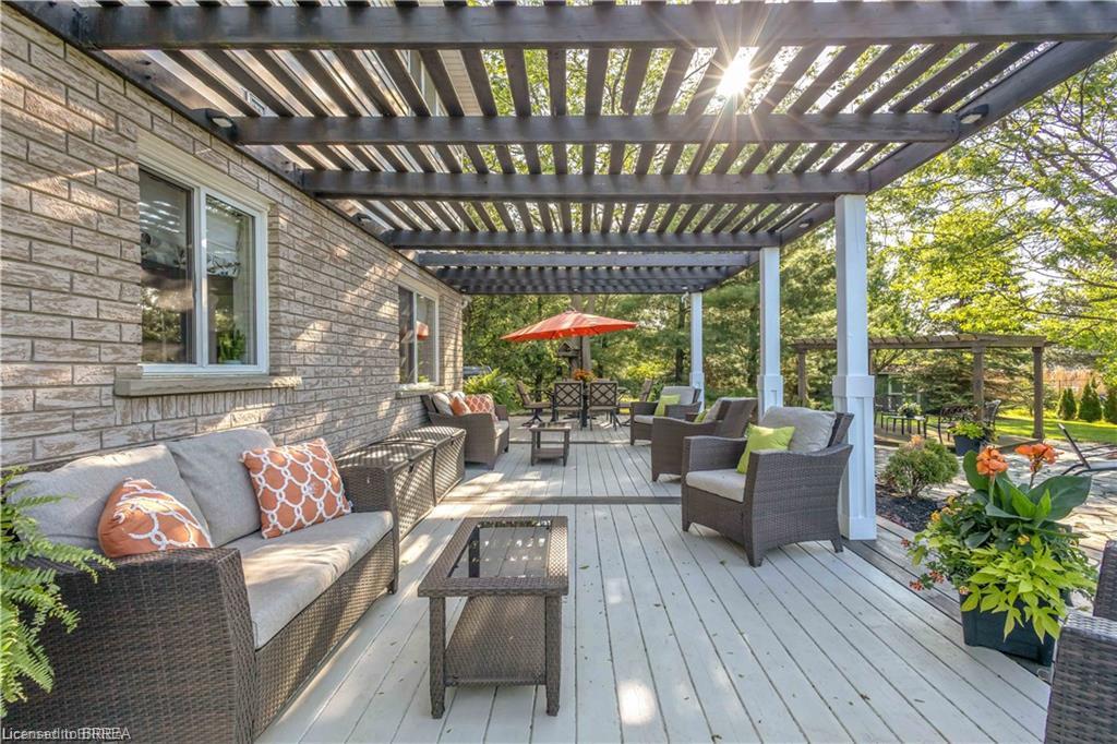 Expansive outdoor deck featuring a dark wood pergola and light-toned decking