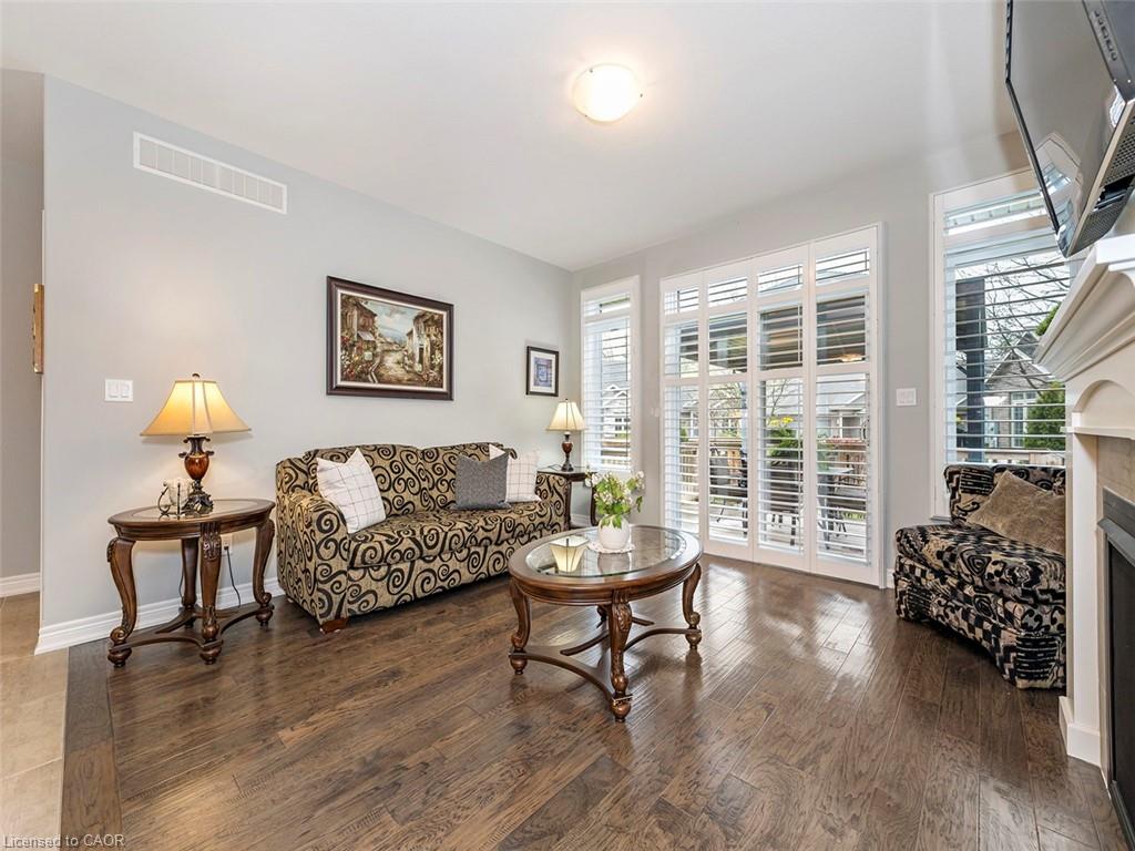 Living area featuring wood-finish flooring, light grey wall tones, and white trim